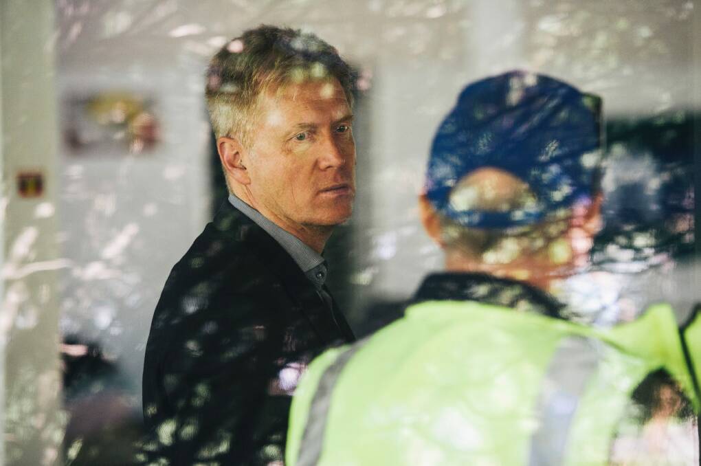 Acting National Capital Authority boss Andrew Smith watches on as police remove activists. Photo: Rohan Thomson