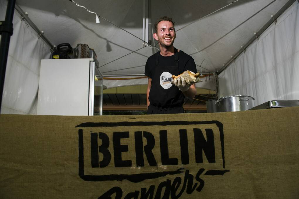Tom Snaith sells a German sausage at the food market at Christmas in the City on Saturday afternoon. Photo: Rohan Thomson