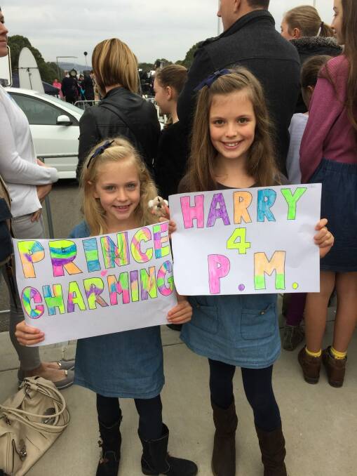 Mia Cooper, 7, with her big sister Ella, 9 wait to meet Prince Harry. Photo: Georgina Connery