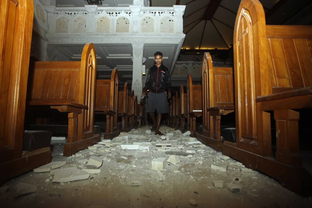 A man walks inside a church where debris has fallen after the earthquake in Bali. Photo: AP