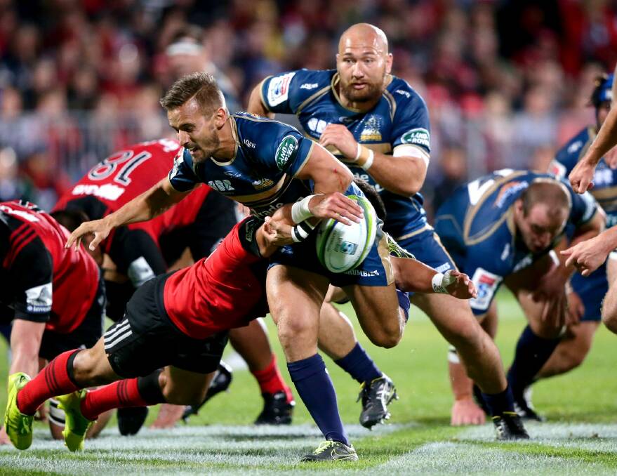 Brumbies De Wet Roos looses the ball as he is tackled during their Super 15 rugby match against the Crusaders. Photo: Mark Baker