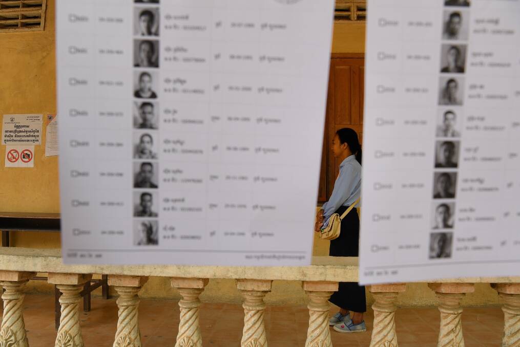 An election official stands among the voter lists at a polling station. Photo: Kate Geraghty 