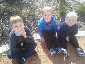 Wanniassa School student Sam Allen, 7; with his brother James, 4, who is in the preschool and their younger brother Liam, 3; in the preschool garden which features bricks with the names of past students. Photo: Supplied