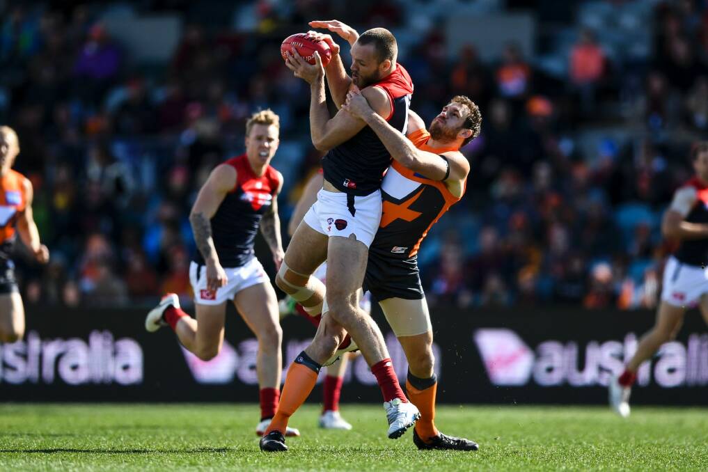 Max Gawin of the Demons (left) fights for the ball with Shane Mumford of the Giants. Photo: Lukas Coch