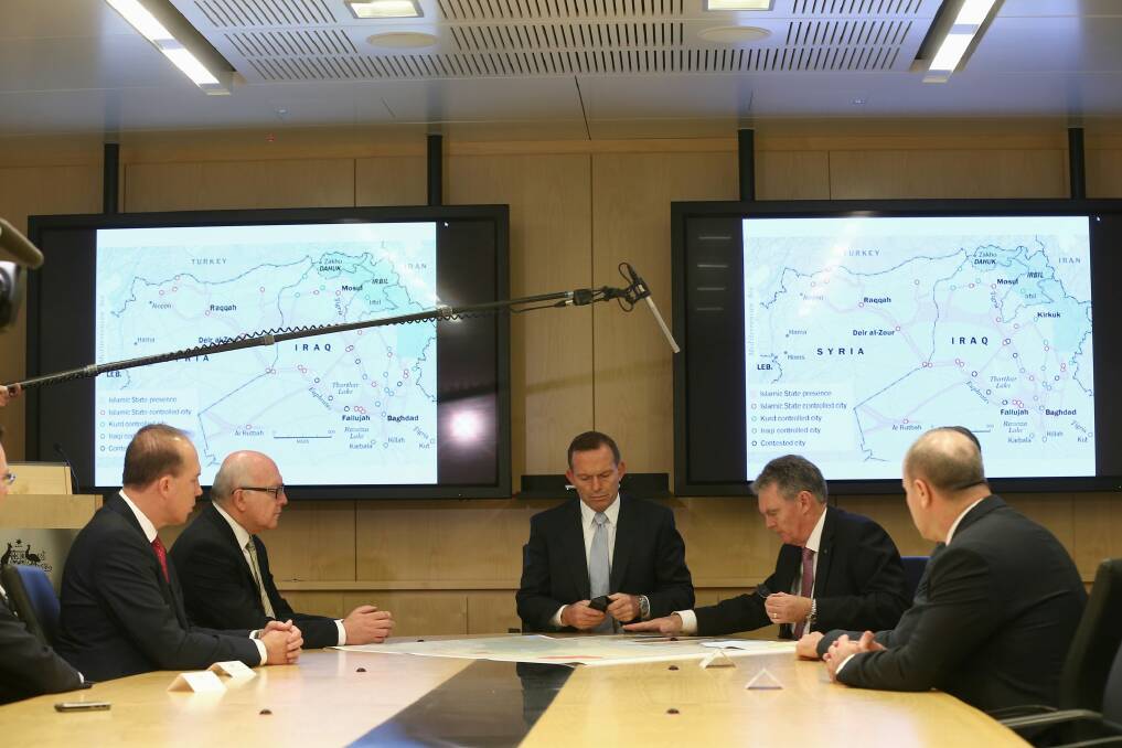 Public secrets: Tony Abbott is filmed receiving a briefing from ASIO Director-General Duncan Lewis. Photo: Alex Ellinghausen