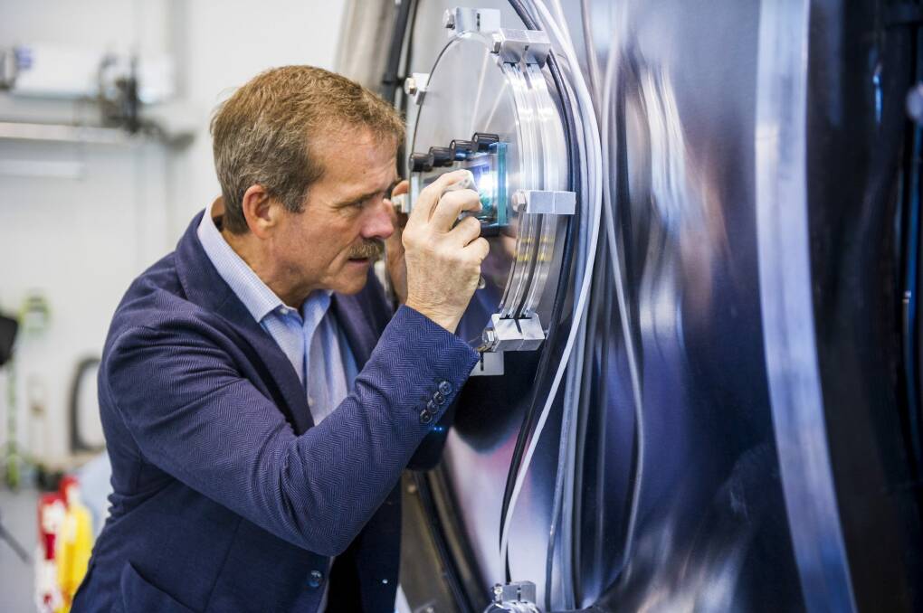 Astronaut Chris Hadfield looks into the WOMBAT space simulation facility during his visit to the ANU. Photo: Rohan Thomson