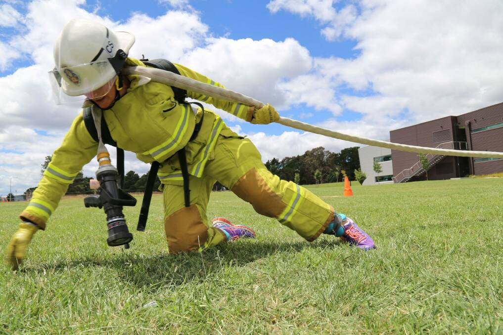ACT Fire and Rescue firefighter Kari Harlovich drags a fire hose attached to a resistance cable today at the ACT Emergency Services Agency headquarters at Fairbairn. Photo: Darren Cutrupi