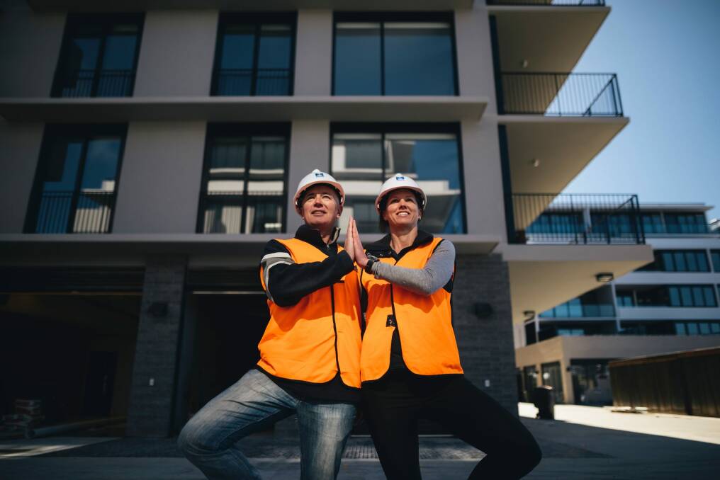 Mindfulness coach Rob Ginnivan and project manager Pip Seldon lead tradies in a yoga class at a building site in Kingston. Photo: Rohan Thomson