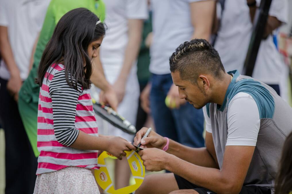 Australian tennis star Nick Kyrgios signing his autograph for eight-year-old Yalini Sundar at the Tennis Carnivale at the Weston Creek Tennis Club on Saturday. Photo: Jamila Toderas