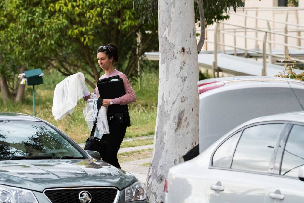 Police remove items including cash in evidence bags from the home. Photo: Rohan Thomson