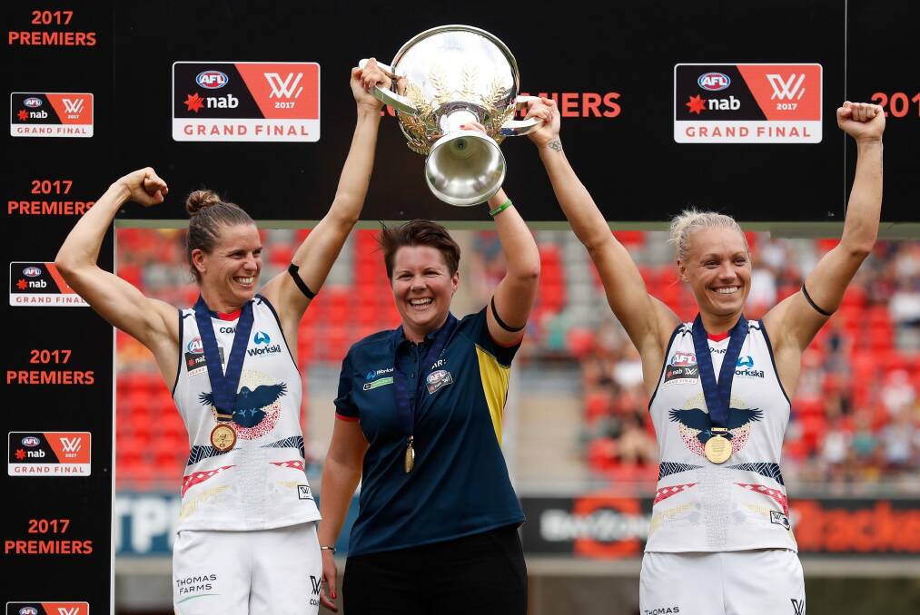 Chelsea Randall, Bec Goddard and Erin Phillip hold the cup aloft. Photo: AFL Media/Getty Images