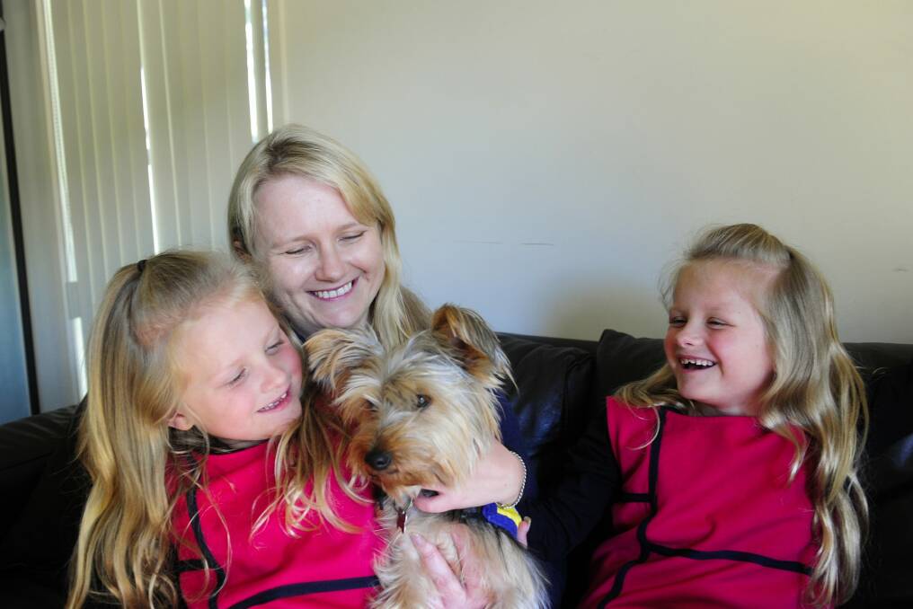 'The biggest hurdle we have faced is people refusing her access to places because she is not a labrador': Adrienne Cottell with her identical twin daughters, Hannah and Olivia Weber, aged 7, and their dog Molly. Photo: Melissa Adams