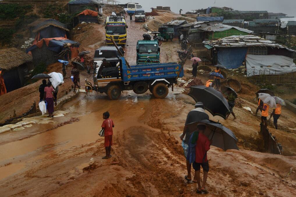 Trucks, rickshaws and people negotiate their way through the mud after a monsoon downpour in Kutupalong Camp this week. Photo: Kate Geraghty
