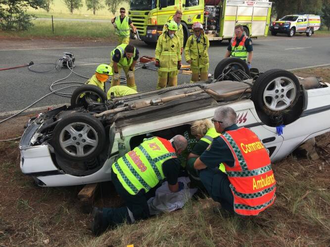 Ambulance officers and firefighters attend a single-vehicle crash on Randwick St in Lyneham on Thursday, January 10, 2018. Photo: ESA