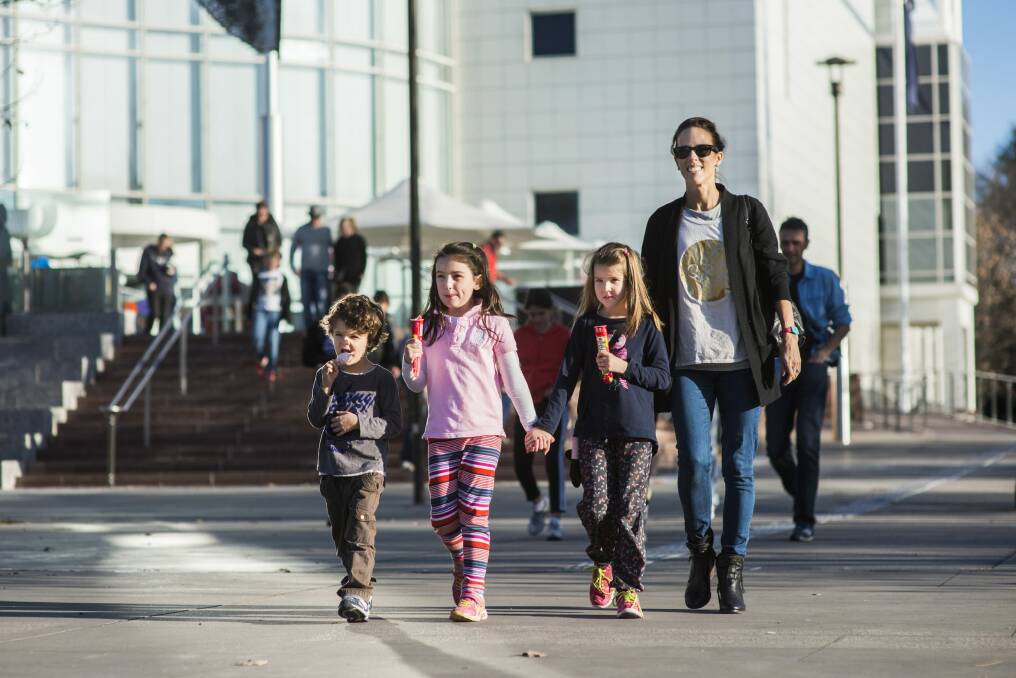 Lisa Postles with Angus Postles, 4, Charlotte Wood, 7, and Abbie Postles, 6, walk with ice creams after their visit to Questacon. Photo: Rohan Thomson