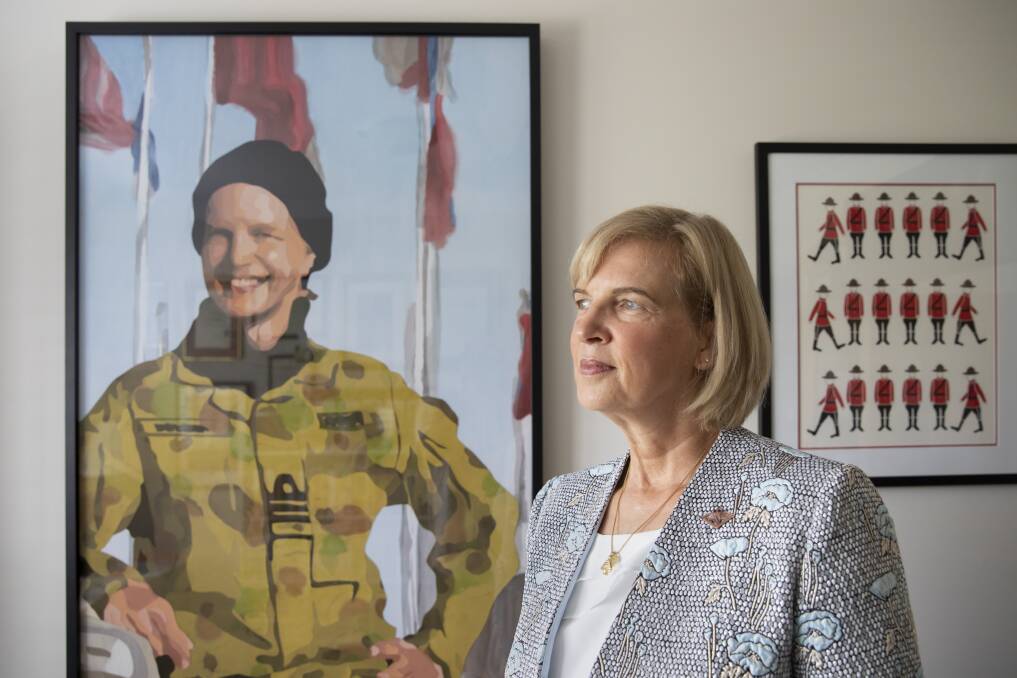 Jennifer Wittwer, gender advisor and former member of the Royal Australian Navy, with a textile portrait of herself by artist Lucy Sattler. Photo: Sitthixay Ditthavong
