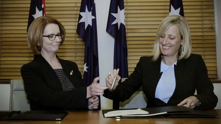 Prime Minister Julia Gillard and ACT Chief Minister Katy Gallagher shared a pen as they signed a National Disability Insurance Scheme agreement at COAG at Parliament House. Photo: Andrew Meares