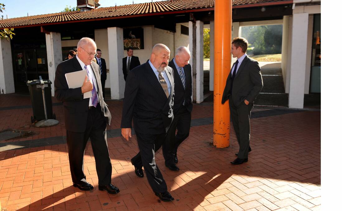 At the scene of an alleged stabbing at Charnwood Shops, prosecuter John Lundy, defence barrister Jack Pappas and Justice Malcolm Gray survey the scene before the jury arrived by bus to inspect the scene.  Photo: Gary Schafer