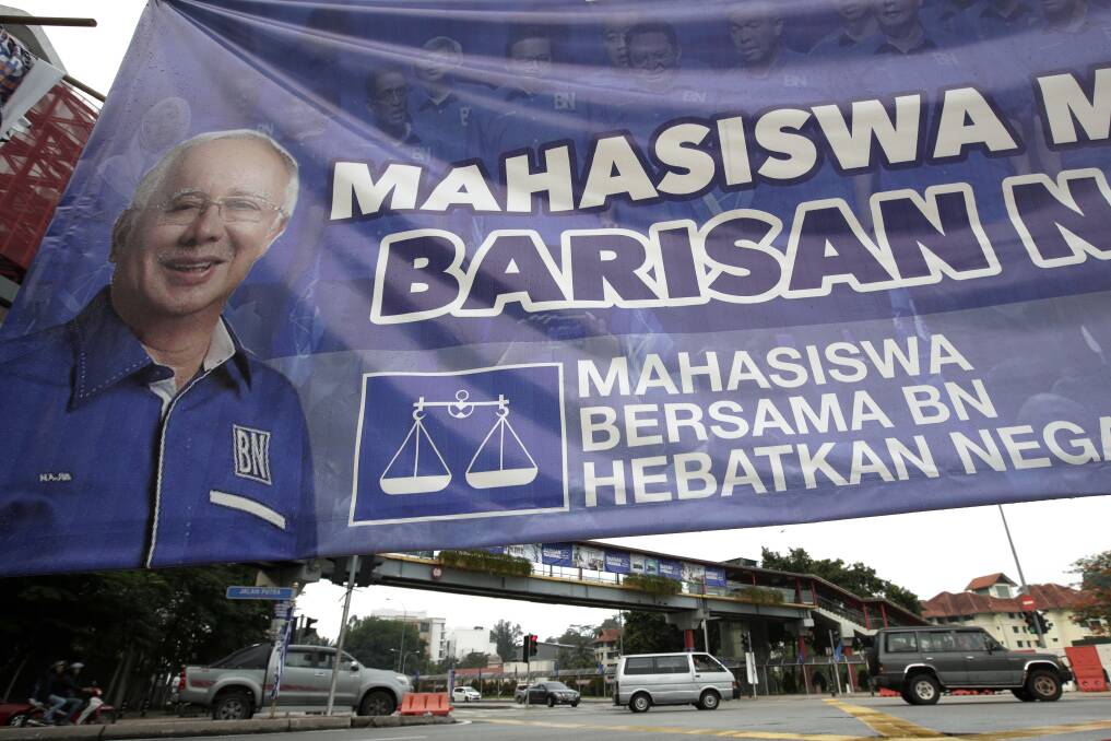 Vehicles pass by a campaign poster of defeated Najib Razak on display along a street in Kuala Lumpur. Photo: AP