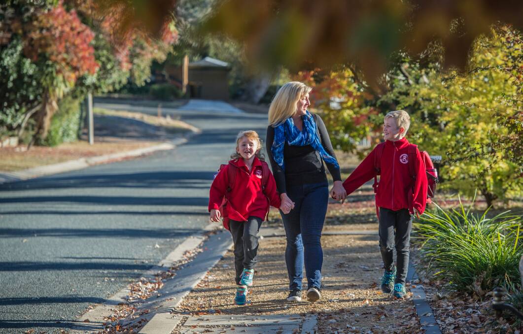 Enjoying a brisk autumn morning on their walk to school are Rivett mum Amanda Corbett and children Hannah, five, and Lachie, eight. Photo: Karleen Minney
