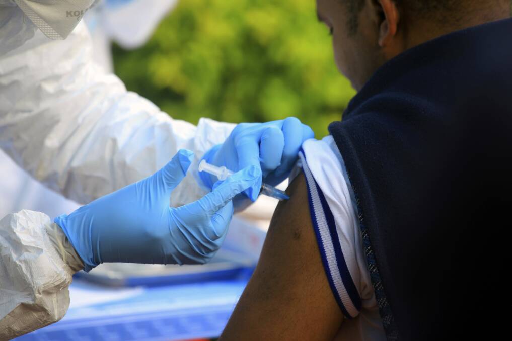 A healthcare worker from the World Health Organisation gives an Ebola vaccination to a front line aid worker in Mangina, Democratic Republic of Congo. Photo: AP
