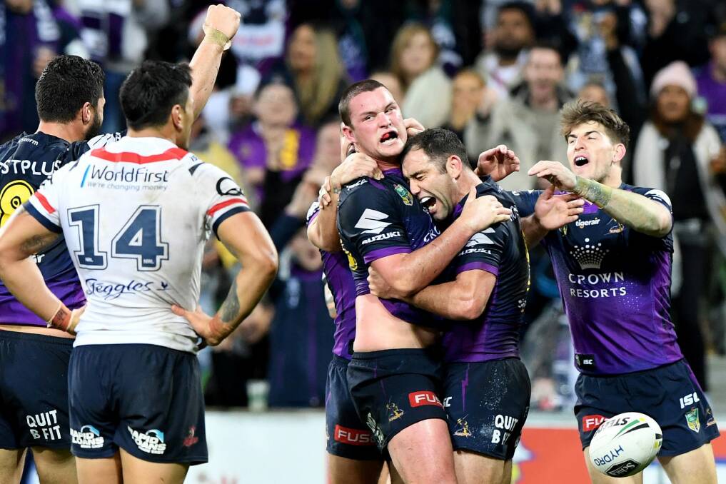 Storm's Joe Stimson is hugged by captain Cameron Smith after his match-winning try against the Roosters. Photo: AAP