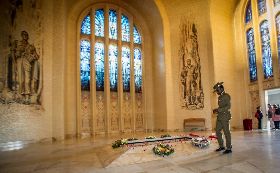 Private Theogene Ngamije places a poppy on the Tomb of the Unknown Australian Soldier.  Photo: karleen minney