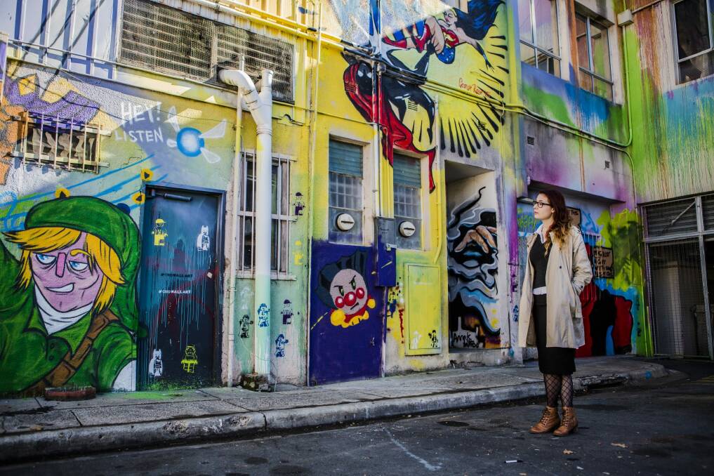 Impact Comics employee Jaisun admires the street art in Tocumwal Lane. The new agenda proposes  making Civic's laneways safer, and sites for art and music. Photo: Jamila Toderas