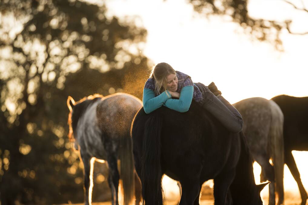 Lauren Woodbridge spends time with her horses while relaxing bareback on Pearl, the first horse she ever trained. Photo: Sitthixay Ditthavong
