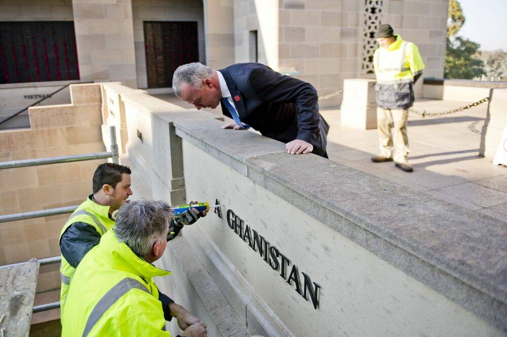 Australian War Memorial director Brendan Nelson inspects the installation of inscriptions of three new theatres of conflict at the Australian War Memorial. Photo: Jay Cronan