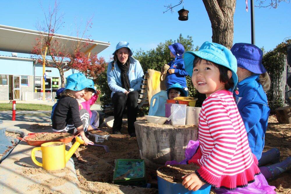 Gungahlin Childcare Centre educator Natalie Higgins with three-year-old Ella Huang and friends.  Photo: Mark Sawa