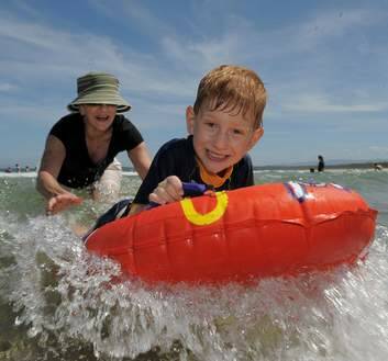Enjoying the surf at South Broulee are Sharon Schaefer of Broulee and her grandson, 6 year old Luke Bombanato of Summer Hill. Photo: Graham Tidy