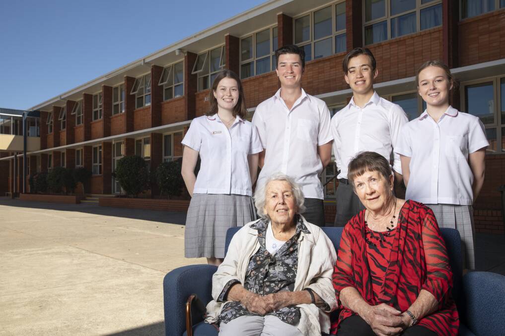 The first female teachers at Daramalan College (Jean Reid, 102, and Mary Barton, 77, on Friday with Year 12 students Rosie Coleman, Josh Low-McMahon, Corey Goodberg, and Abby Thomas. They are outside the teaching wing named in Mrs Reid's honour. Photo: Sitthixay Ditthavong