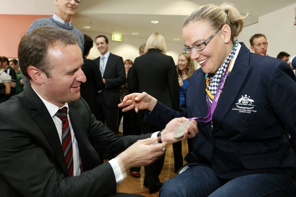 Andrew Barr in 2012 looking at Louise Ellery's silver medial which she won in shotput at the London Paralympic Games. Photo: Jeffrey Chan