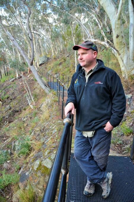 Darren Stewart, of Makin Trax, enjoys the view from a new bridge on the Black Mountain Forest Trail. Photo: Tim the Yowie Man