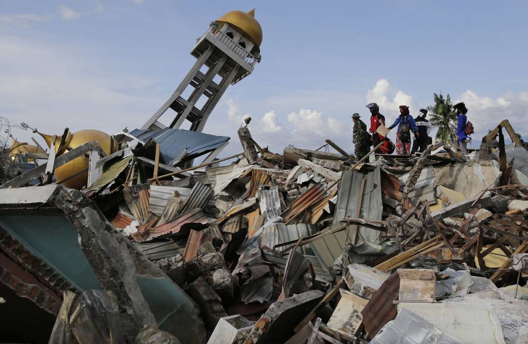 Villagers wait for any word on their missing relatives lost in the Balarola neighbourhood of Palu city. Photo: AP