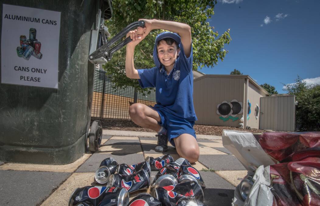 Eco-detective at Garran Primary Rex Martin, 10, crushes collected cans as part of the school's extensive recycling program. Photo: Karleen Minney