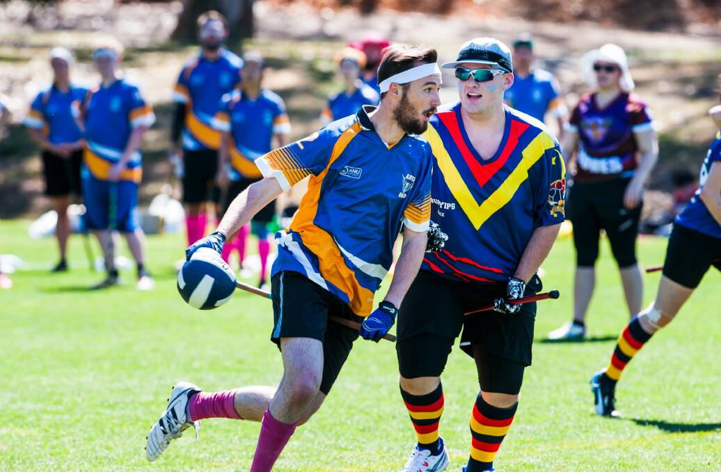 Competitors compete in Quidditch with broomsticks between their legs. Photo: Elesa Kurtz