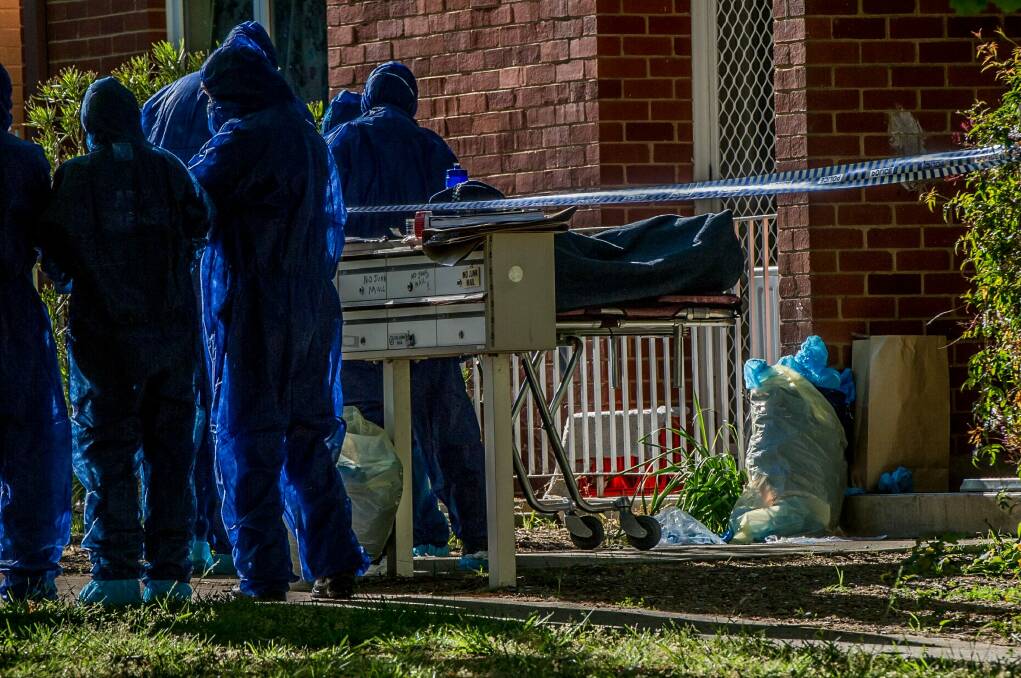 ACT police officers remove a dead body from a block of flats in Windeyer street Watson. Photo: Karleen Minney