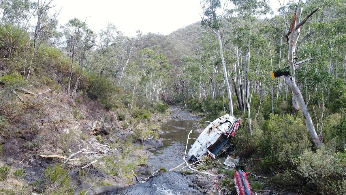 The wreckage of a UH-1H helicopter lies in the Yarrangobilly River after it was destroyed in a crash in April. Photo: Australian Transport Safety Bureau