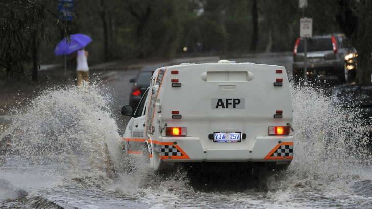 A police car makes it way through a flooded street. Photo: Graham Tidy