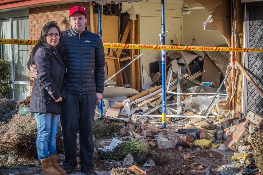 Newlyweds Catia Ochi and Colin Tucker outside their home on Deamer Crescent, Richardson, where a car came through the front wall on Wednesday morning. Photo: Karleen Minney