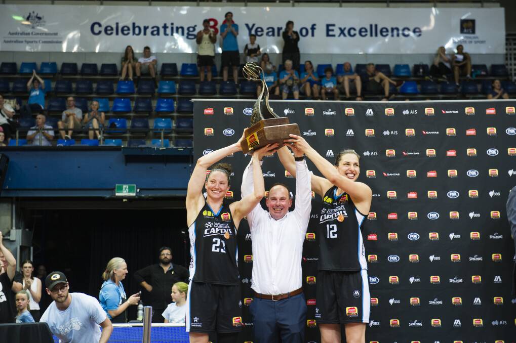 Kelsey Griffin, coach Paul Goriss and Marianna Tolo hold the WNBL championship trophy. Photo: Dion Georgopoulos