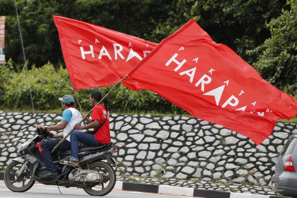 Supporters ride with flags of Pakatan Harapan (Alliance of Hope) as Anwar Ibrahim arrives at a polling station in the southern coastal town of Port Dickson. Photo: AP