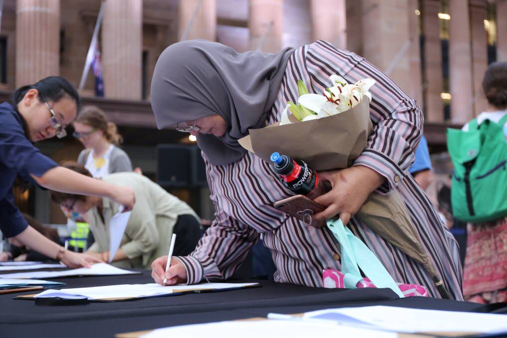 Muslima Fadia Shamseldin signing the condolence book for the Christchurch victims. Photo: Jocelyn Garcia
