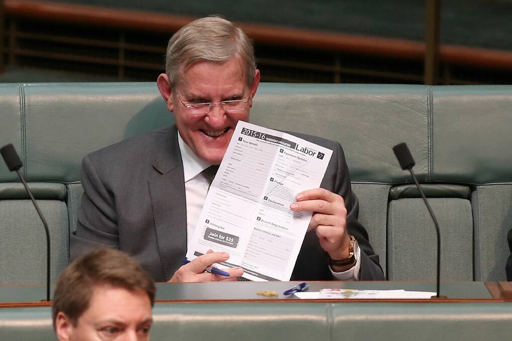Former Liberal minister Ian Macfarlane holds up an ALP membership form, sent to him during Question Time on Thursday. Photo: Alex Ellinghausen