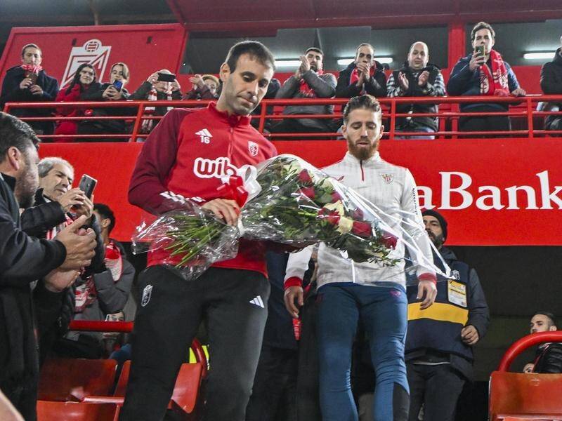 The captains of both sides lay flowers on the seat of a fan who died at the Granada-Athletic match. (EPA PHOTO)