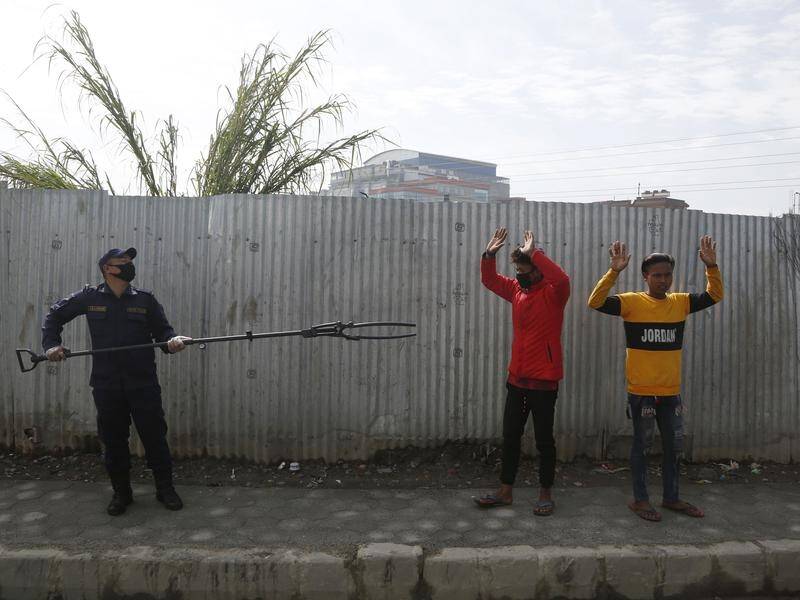 Police in Nepal are using a pole with a clamp attached to nab violators of a coronavirus lockdown.
