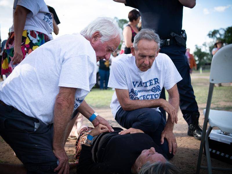 Former Greens leader Bob Brown comforted a woman injured during an anti-Adani event in Queensland.