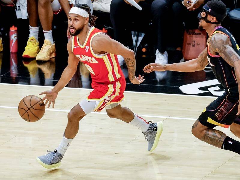 Patty Mills, on the ball against Phoenix, has been waived by the NBA's Atlanta Hawks. (EPA PHOTO)